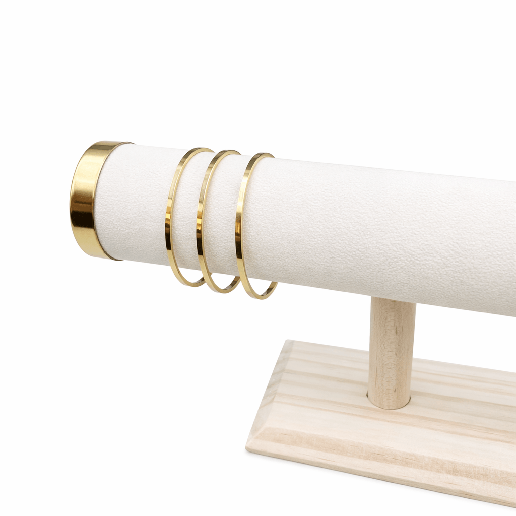 gold flat bangle on a stand