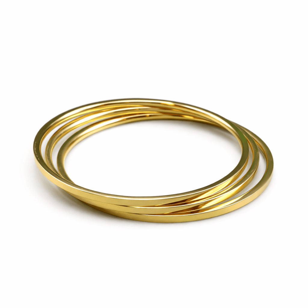 Three gold bangles stacked on a white background