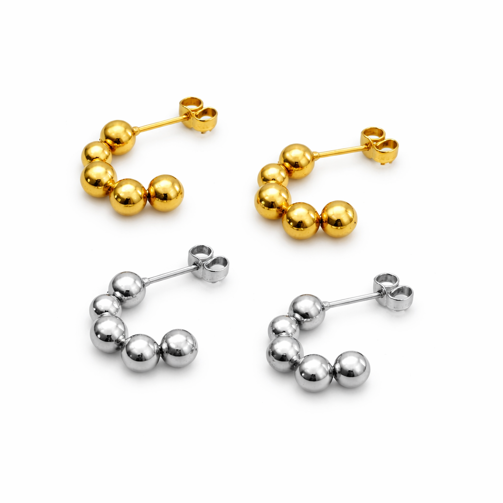Pair of gold hoop earrings and a pair of silver hoop earrings on a white background
