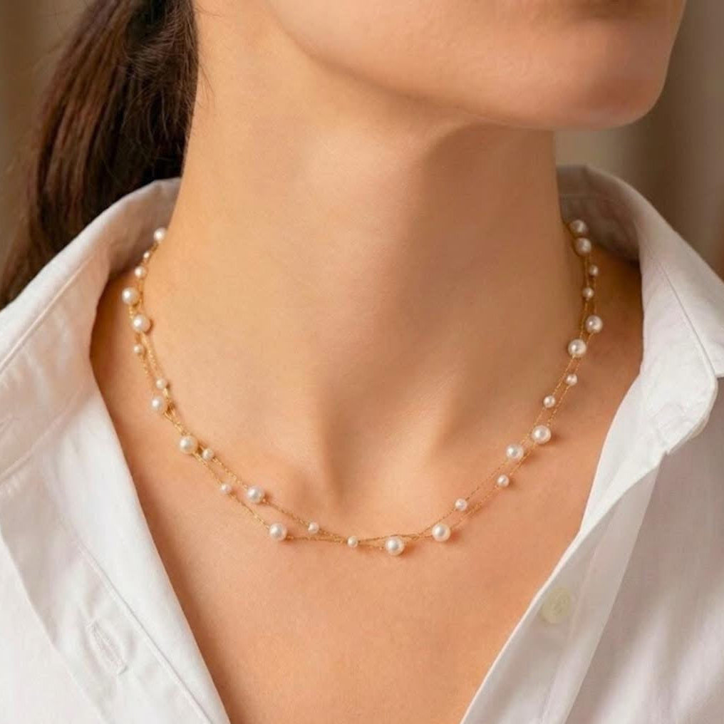 Pearl necklace worn by a person with a white shirt