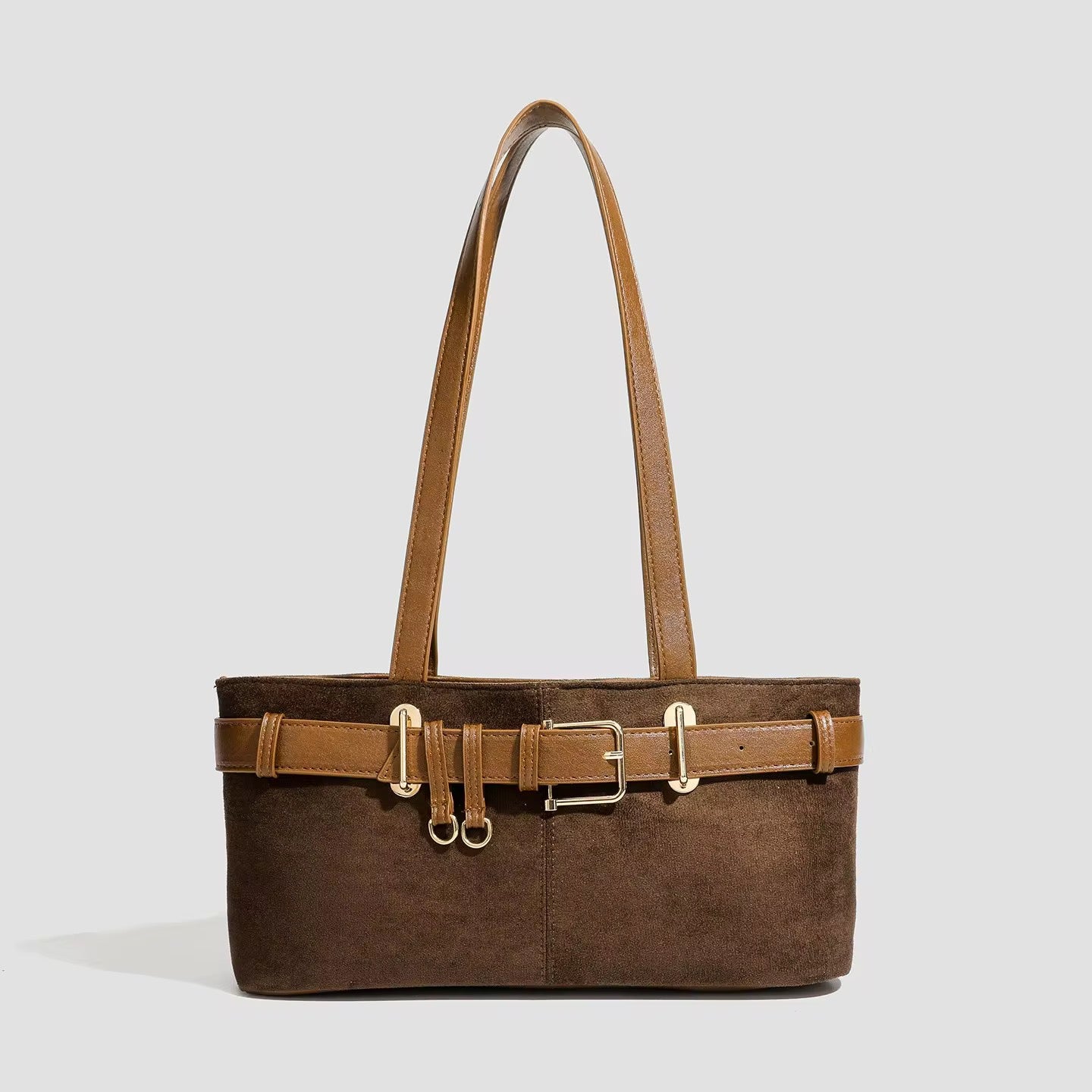 Brown suede handbag with gold buckle on a light gray background